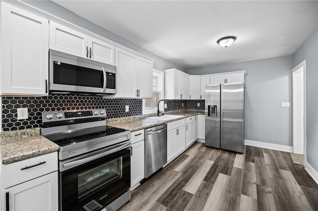 kitchen featuring white cabinetry, sink, light stone counters, and stainless steel appliances