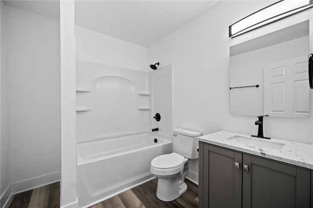 full bathroom with hardwood / wood-style flooring, vanity, washtub / shower combination, and toilet