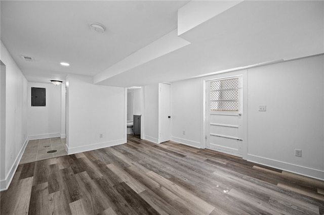 basement with dark wood-type flooring and electric panel