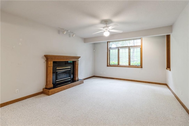 unfurnished living room featuring ceiling fan, rail lighting, and light colored carpet