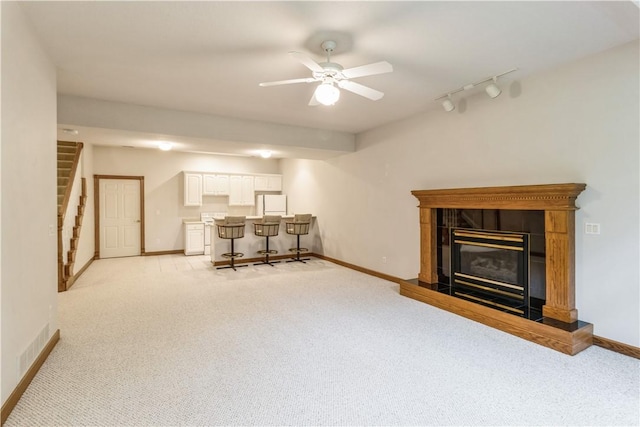 carpeted living room featuring ceiling fan and track lighting