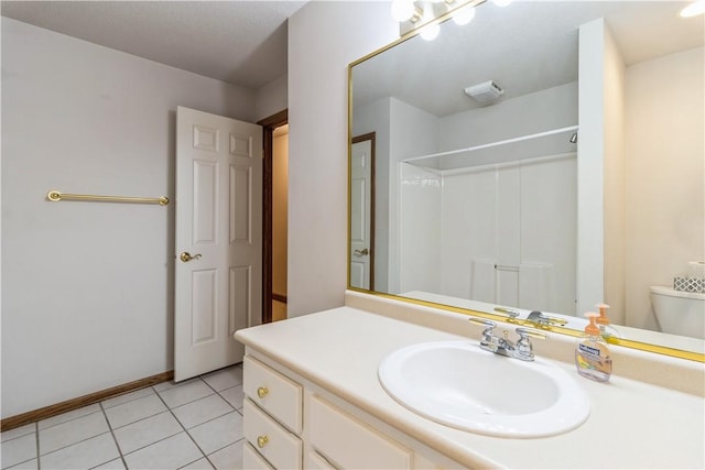 bathroom with toilet, a shower, vanity, and tile patterned floors