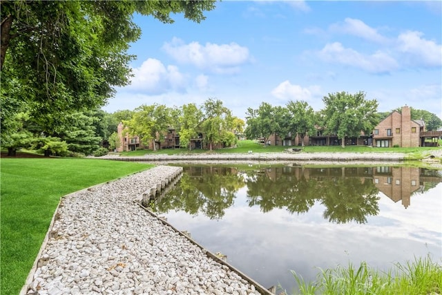 view of property's community with a lawn and a water view