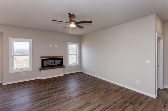 unfurnished living room with ceiling fan and dark wood-type flooring