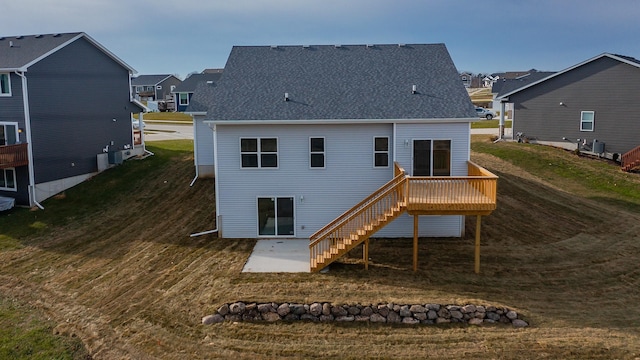 rear view of property featuring a deck and a lawn