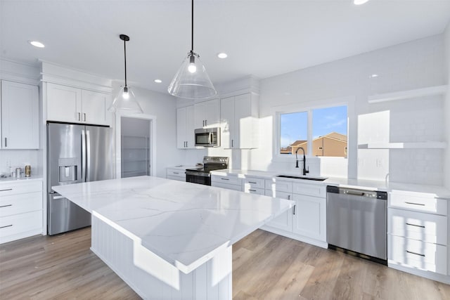 kitchen featuring white cabinetry, sink, a center island, and appliances with stainless steel finishes