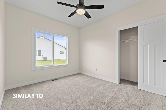 unfurnished bedroom featuring ceiling fan, light carpet, and a closet