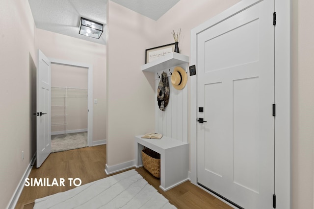 mudroom featuring a textured ceiling and light hardwood / wood-style floors