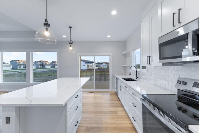 kitchen featuring a center island, appliances with stainless steel finishes, sink, and white cabinets