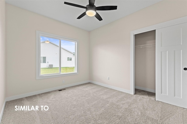 unfurnished bedroom featuring light carpet, ceiling fan, and a closet