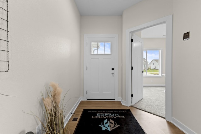 doorway to outside with light colored carpet