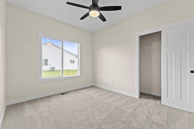 unfurnished bedroom with ceiling fan, a closet, and light carpet