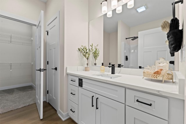 bathroom with walk in shower, vanity, and wood-type flooring