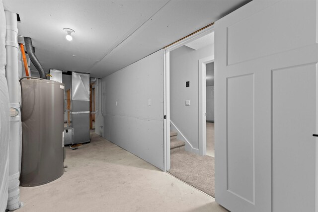 basement featuring heating unit, light carpet, and water heater