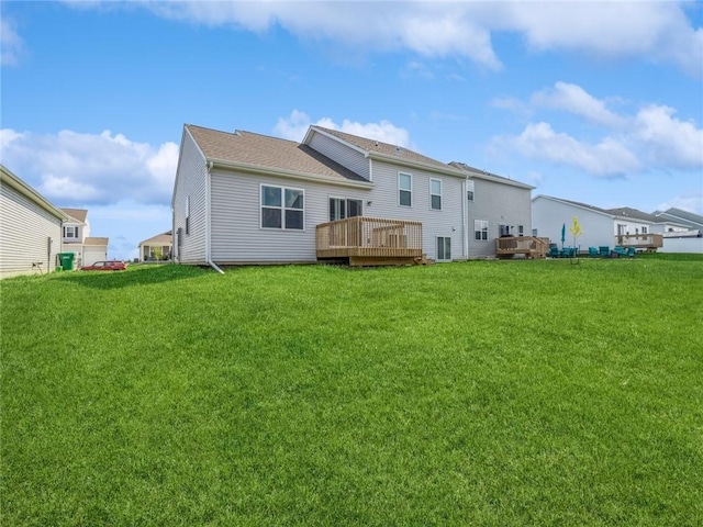 back of property with a yard and a wooden deck