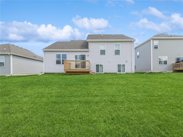 back of house featuring a lawn and a deck