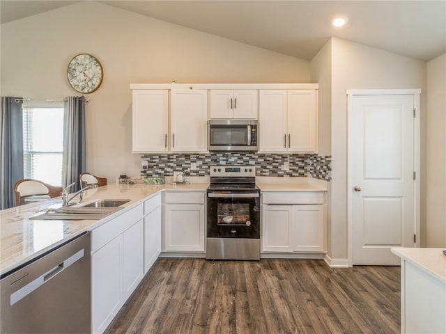 kitchen featuring white cabinetry, lofted ceiling, appliances with stainless steel finishes, and dark wood-type flooring