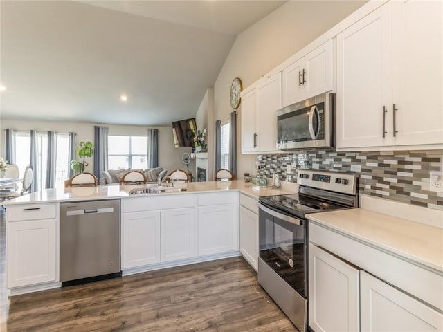 kitchen featuring decorative backsplash, stainless steel appliances, light countertops, and a sink