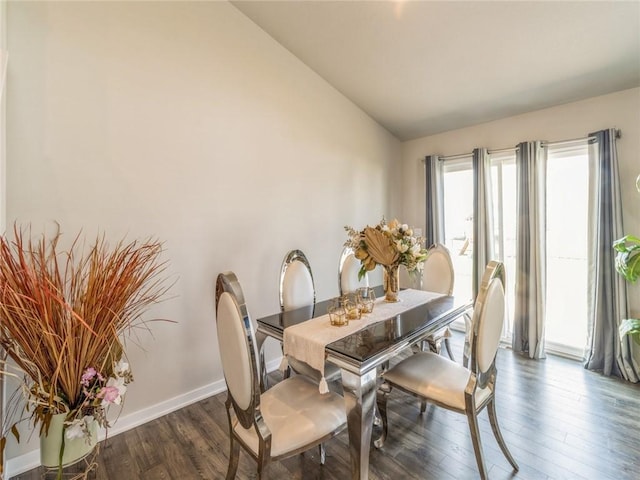 dining area featuring baseboards, lofted ceiling, and dark wood-style flooring