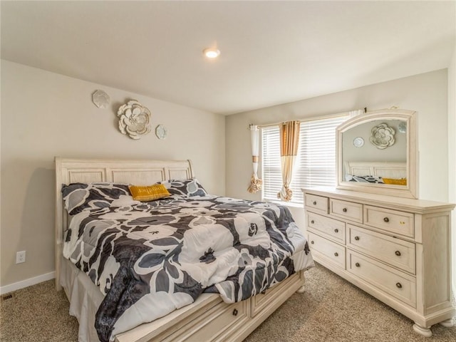 bedroom with light colored carpet and baseboards