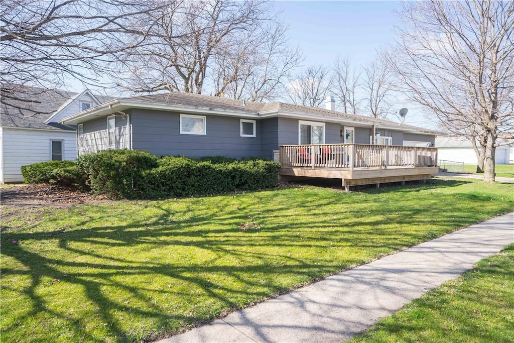 view of front facade featuring a front yard and a wooden deck