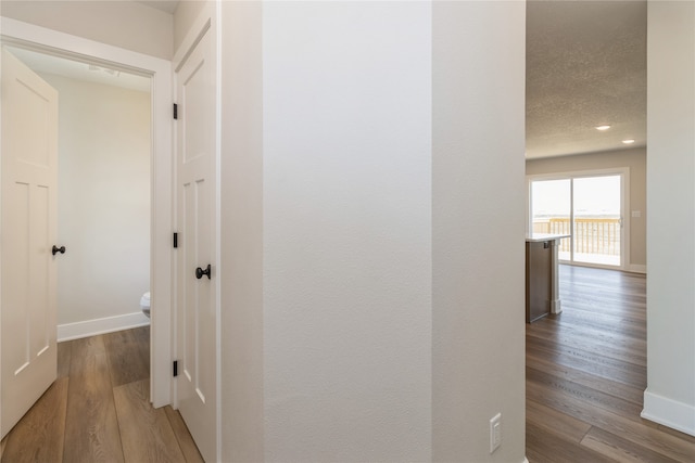 hallway featuring a textured ceiling and wood-type flooring