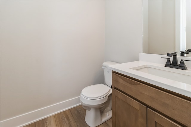 bathroom featuring vanity, hardwood / wood-style flooring, and toilet