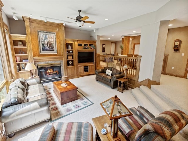 living room with light carpet, built in features, and ceiling fan