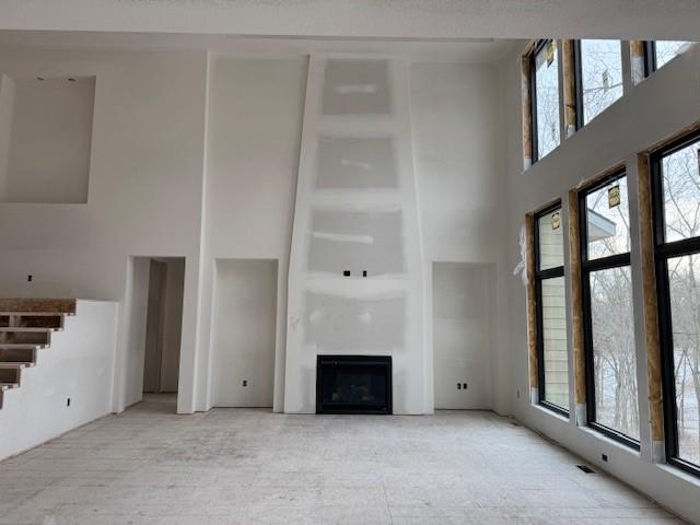 unfurnished living room with a towering ceiling