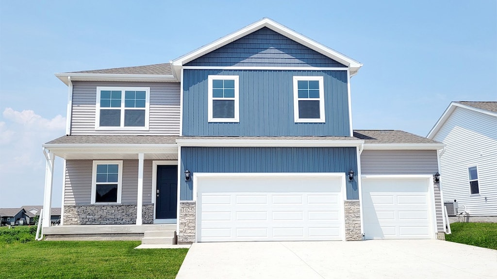 view of front of house with a garage, a front yard, and covered porch