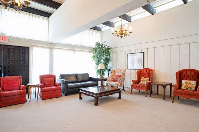 carpeted living room featuring beamed ceiling, a high ceiling, and a notable chandelier