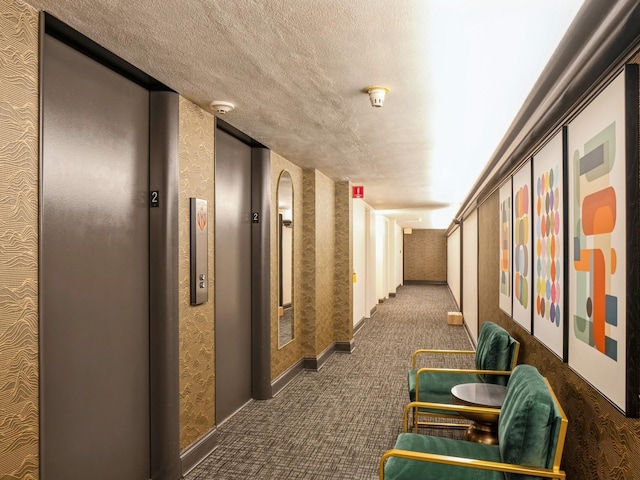 hall with a textured ceiling and elevator