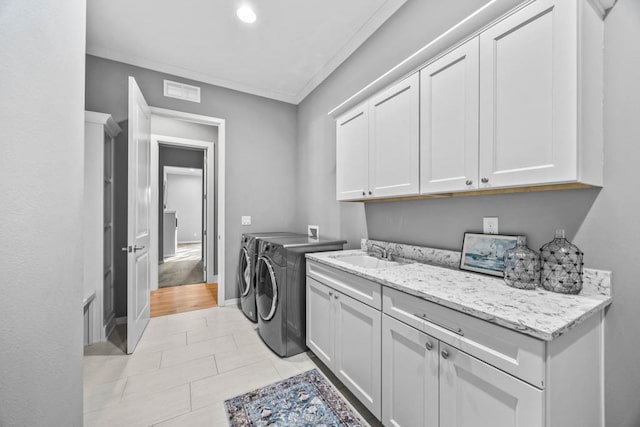 laundry room featuring cabinets, separate washer and dryer, crown molding, and light tile patterned floors