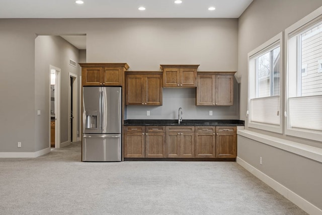 kitchen featuring sink, stainless steel fridge with ice dispenser, and light carpet