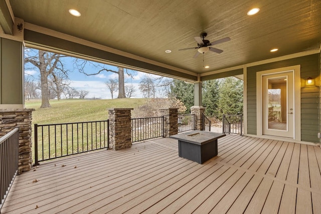 deck featuring a yard, ceiling fan, and an outdoor fire pit