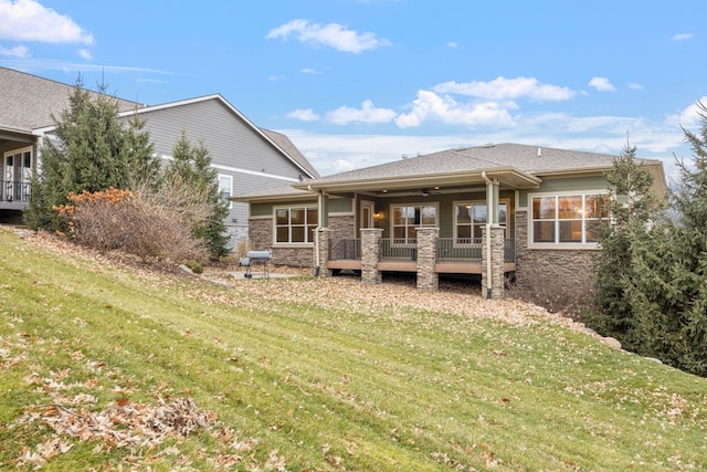 rear view of house featuring a lawn and ceiling fan