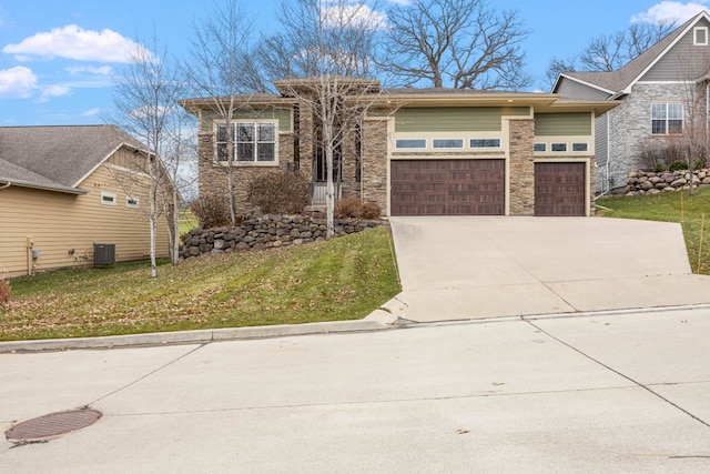 view of front of home featuring central air condition unit, a front yard, and a garage