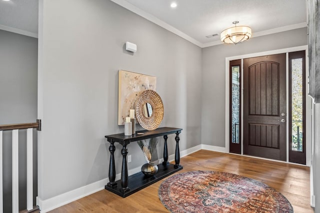 entrance foyer with hardwood / wood-style floors and ornamental molding