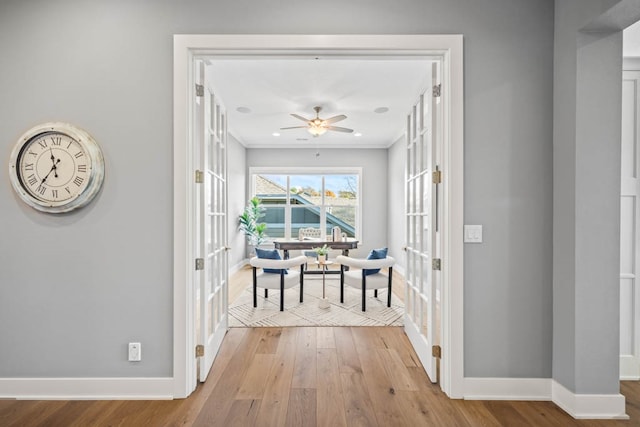 corridor featuring ornamental molding, light hardwood / wood-style flooring, and french doors