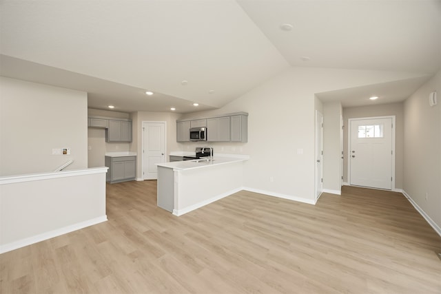 kitchen with gray cabinets, light hardwood / wood-style flooring, and lofted ceiling