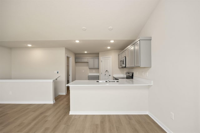 800 Linden St, Carlisle, IA 50047 - kitchen featuring stainless steel appliances, a sink, gray cabinetry, a peninsula, and baseboards
