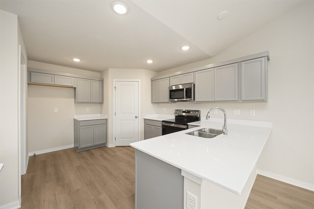 kitchen featuring light wood-type flooring, stainless steel appliances, gray cabinets, and sink