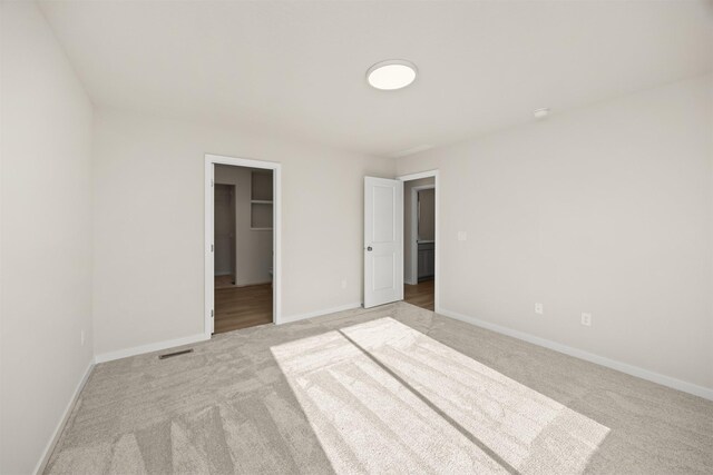 800 Linden St, Carlisle, IA 50047 - unfurnished bedroom with light colored carpet, baseboards, and a spacious closet