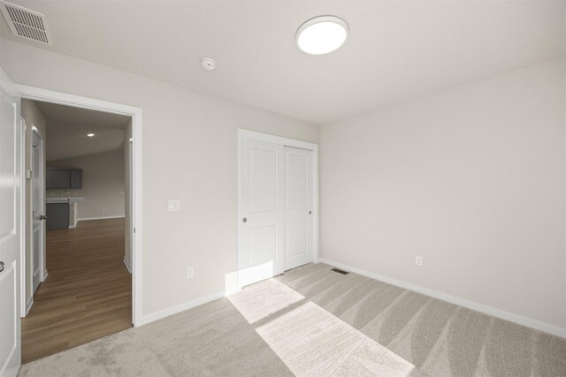 800 Linden St, Carlisle, IA 50047 - unfurnished bedroom featuring baseboards, carpet, a closet, and a sink
