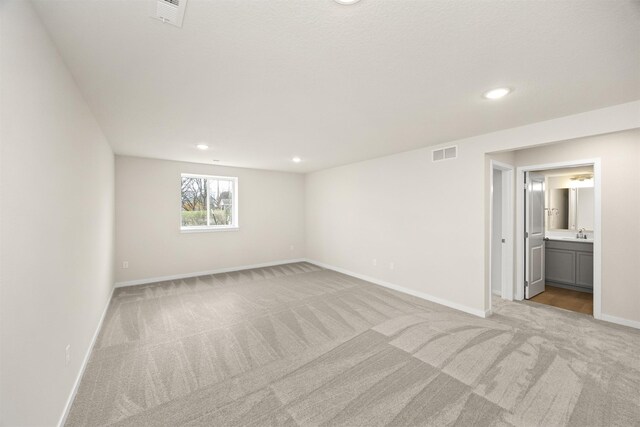 800 Linden St, Carlisle, IA 50047 - empty room featuring light carpet, baseboards, recessed lighting, and a sink