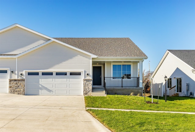 view of front of home featuring a garage, a porch, and a front lawn