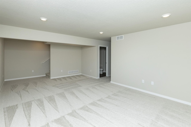 6570 NE 11th Ct, Des Moines, IA 50313 - spare room with light carpet, baseboards, stairs, and recessed lighting