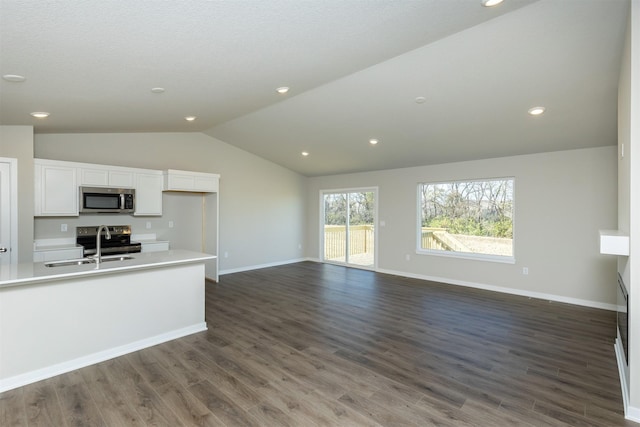 6570 NE 11th Ct, Des Moines, IA 50313 - unfurnished living room with lofted ceiling, a sink, dark wood finished floors, baseboards, and recessed lighting