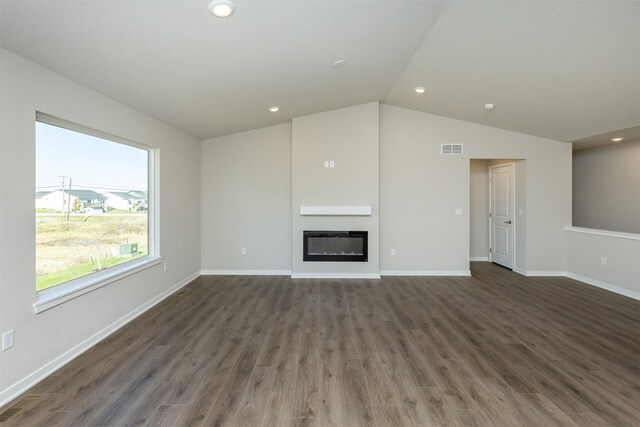 6570 NE 11th Ct, Des Moines, IA 50313 - unfurnished living room with lofted ceiling, wood finished floors, a glass covered fireplace, baseboards, and recessed lighting
