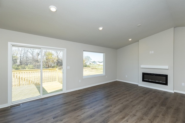 6570 NE 11th Ct, Des Moines, IA 50313 - unfurnished living room with lofted ceiling, dark wood-type flooring, a glass covered fireplace, baseboards, and recessed lighting